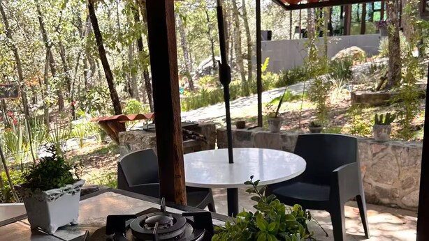 An outdoor patio with a round table, chairs, a gas stove, and potted plants. - Lenna por GEstores (Huasca De Ocampo)