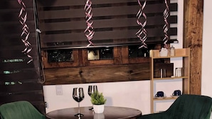 A round table with two green chairs, a potted plant, and two wine glasses. - Lenna por GEstores (Huasca De Ocampo)