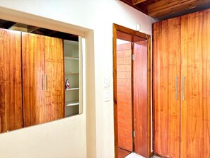 Ein Zimmer mit Holzschränken, einer weißen Wand und einer sichtbaren Steckdose.