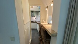A narrow hallway leading to a kitchen with a dining area. - Nature Escape Home Near Veere (Gapinge)