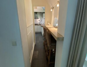 Ein schmaler Flur führt zu einer Küche mit Essbereich.