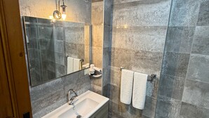 A modern bathroom with a large mirror, a sink, and a shower area. - Sais Hotel Kaleiçi (Antalya)