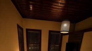 A bedroom with a bed, a chair, a TV, and a patterned rug. - Sais Hotel Kaleiçi (Antalya)