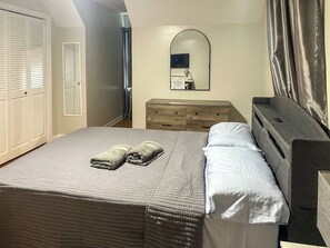 Una habitación de hotel con cama, cómoda, espejo y armario.