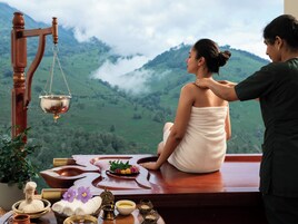A person receiving a massage in a room with a view of mountains.