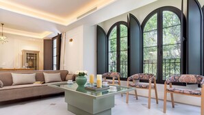A modern living room with a sofa, chairs, a glass coffee table, and large windows. - Unique House With Private Terrace Casa Pilatos (Seville)