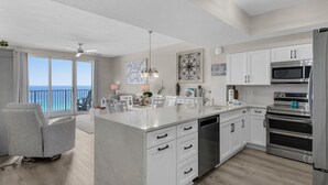 Una cocina moderna con muebles blancos, electrodomésticos de acero inoxidable y una isla grande.