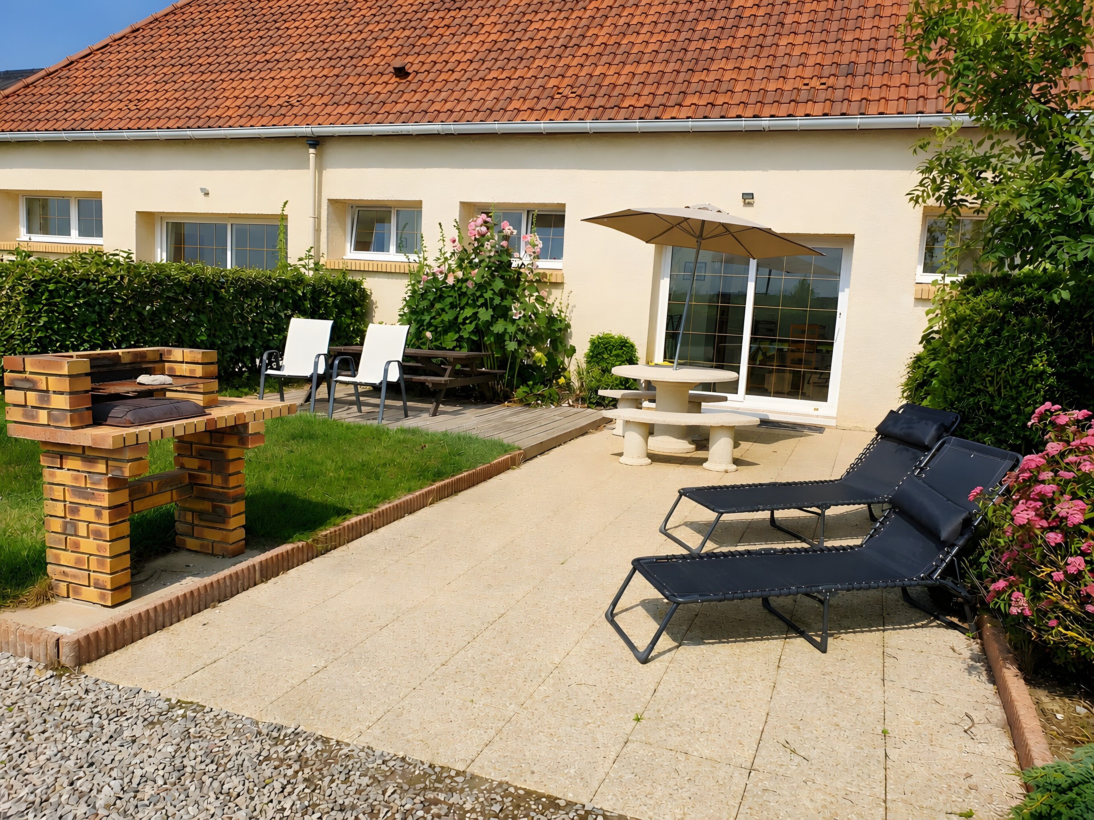 A patio area with a brick oven, outdoor seating, and a table with an umbrella.
