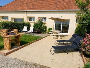 A patio area with a brick oven, outdoor seating, and a table with an umbrella.