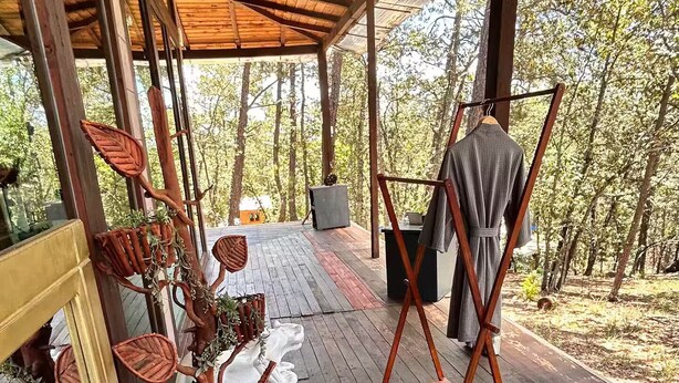 A covered outdoor area with a wooden deck, a hot tub, and a rustic wooden structure with a hanging chair. - Constanza de GEstores (Huasca De Ocampo)