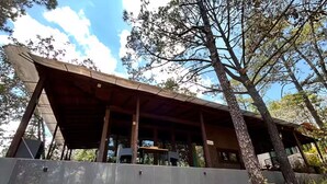 A modern building with a flat roof, large windows, and a stone wall. - Constanza de GEstores (Huasca De Ocampo)