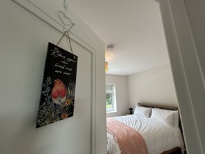 Ein Schlafzimmer mit Bett, Nachttisch und Wandbild.