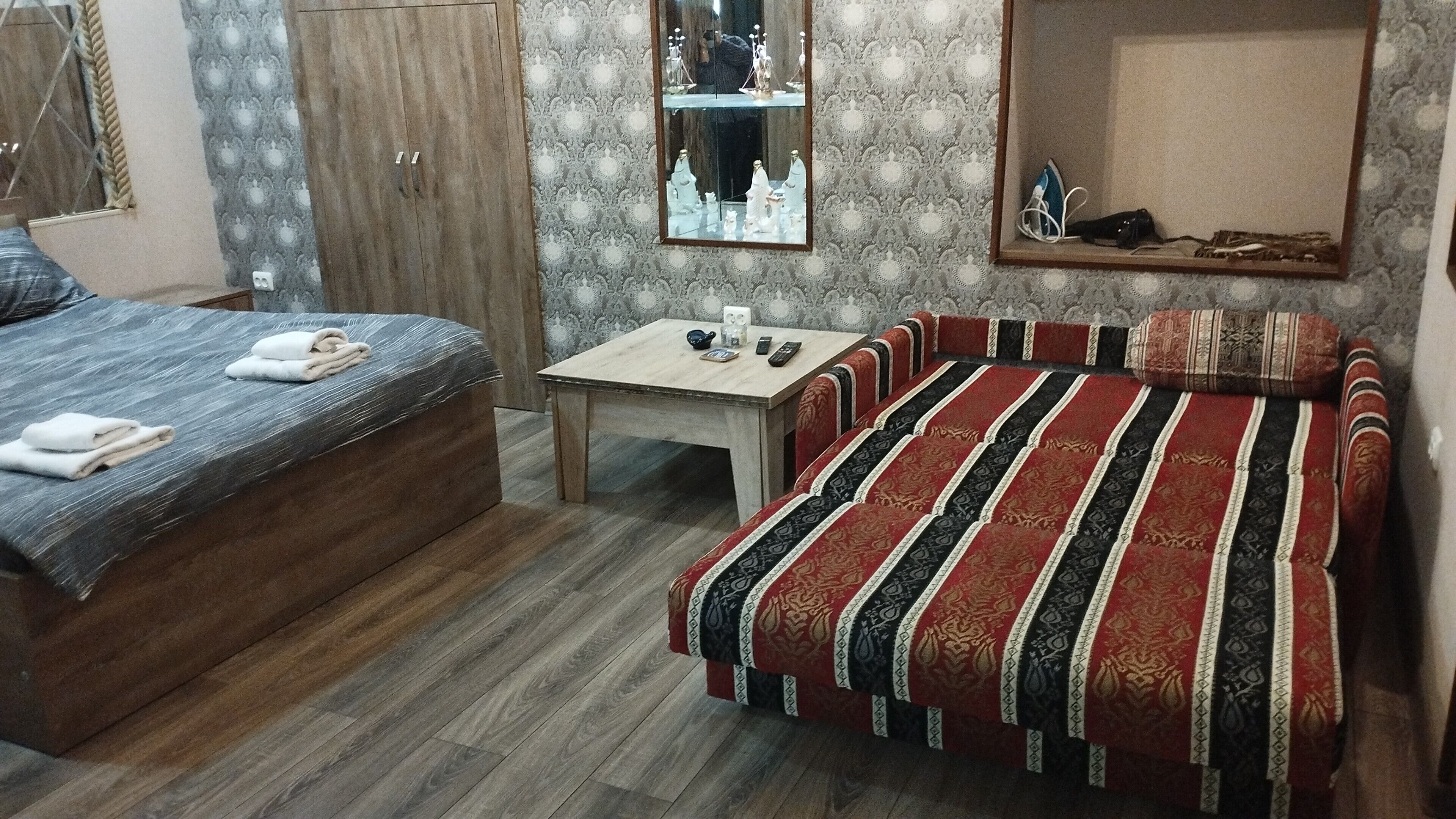 Une chambre à coucher avec un lit, une table et un miroir.