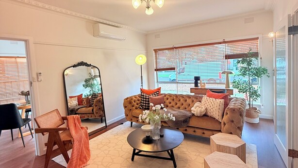 Un salón amplio con un sofá grande, una mesa de centro y una zona de comedor con una silla y una mesa.