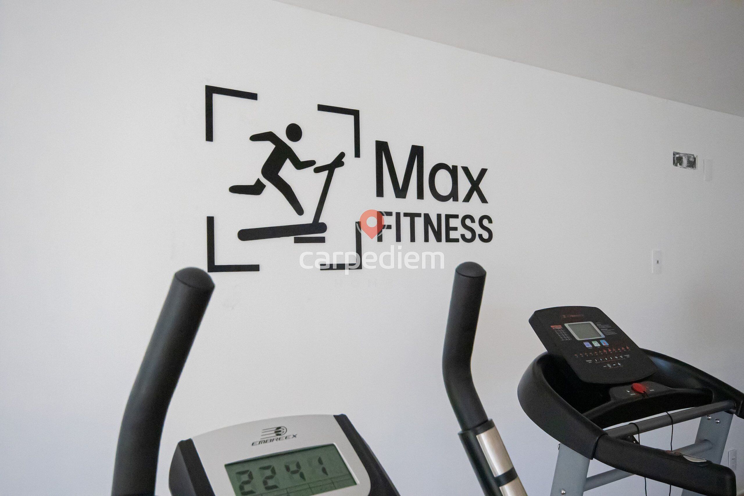 A treadmill, a digital display, and a wall with a fitness-related logo and text.