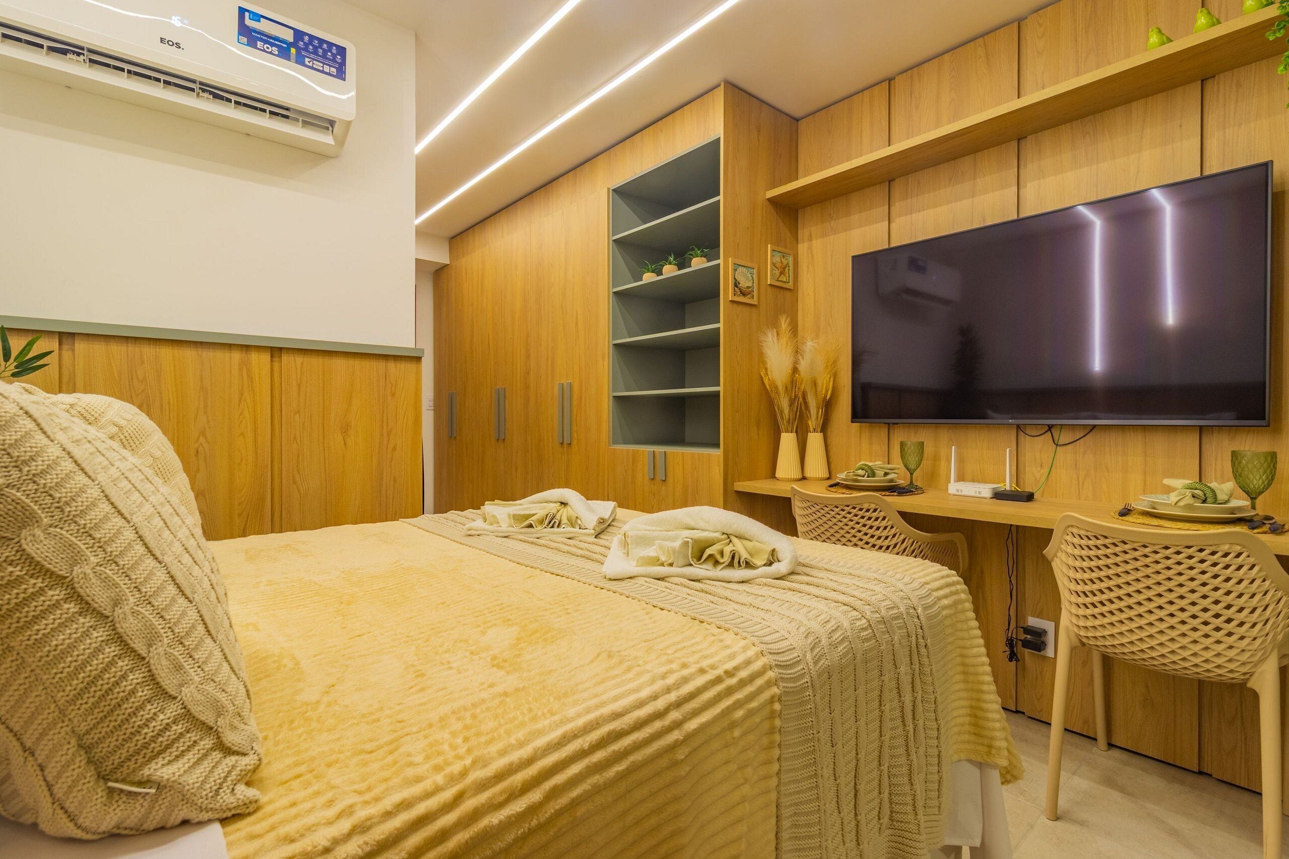 Ein Hotelzimmer mit Bett, Schreibtisch, Fernseher und Kleiderschrank.