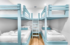 A room with bunk beds, a central ladder, and white bedding. - Sundance @ St. George Island (Saint George Island)