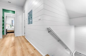 A modern interior with a wooden floor, white walls, and a green accent wall. - Sundance @ St. George Island (Saint George Island)