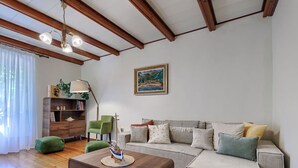 A living room with a wooden ceiling, a green armchair, a striped sofa, and a wooden coffee table. - Stunning private villa for 6 guests with A/C, WIFI, TV and terrace (Pazin)
