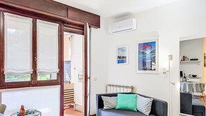 Een moderne woonkamer met een bank, een bijzettafeltje en uitzicht op de omgeving.