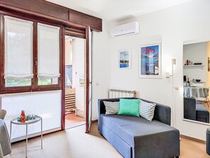 Ein modernes Wohnzimmer mit einer Couch, einem kleinen Tisch und Blick ins Freie.