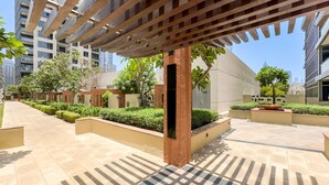 Un espace extérieur moderne agrémenté d’une pergola, de jardinières et d’un chemin.