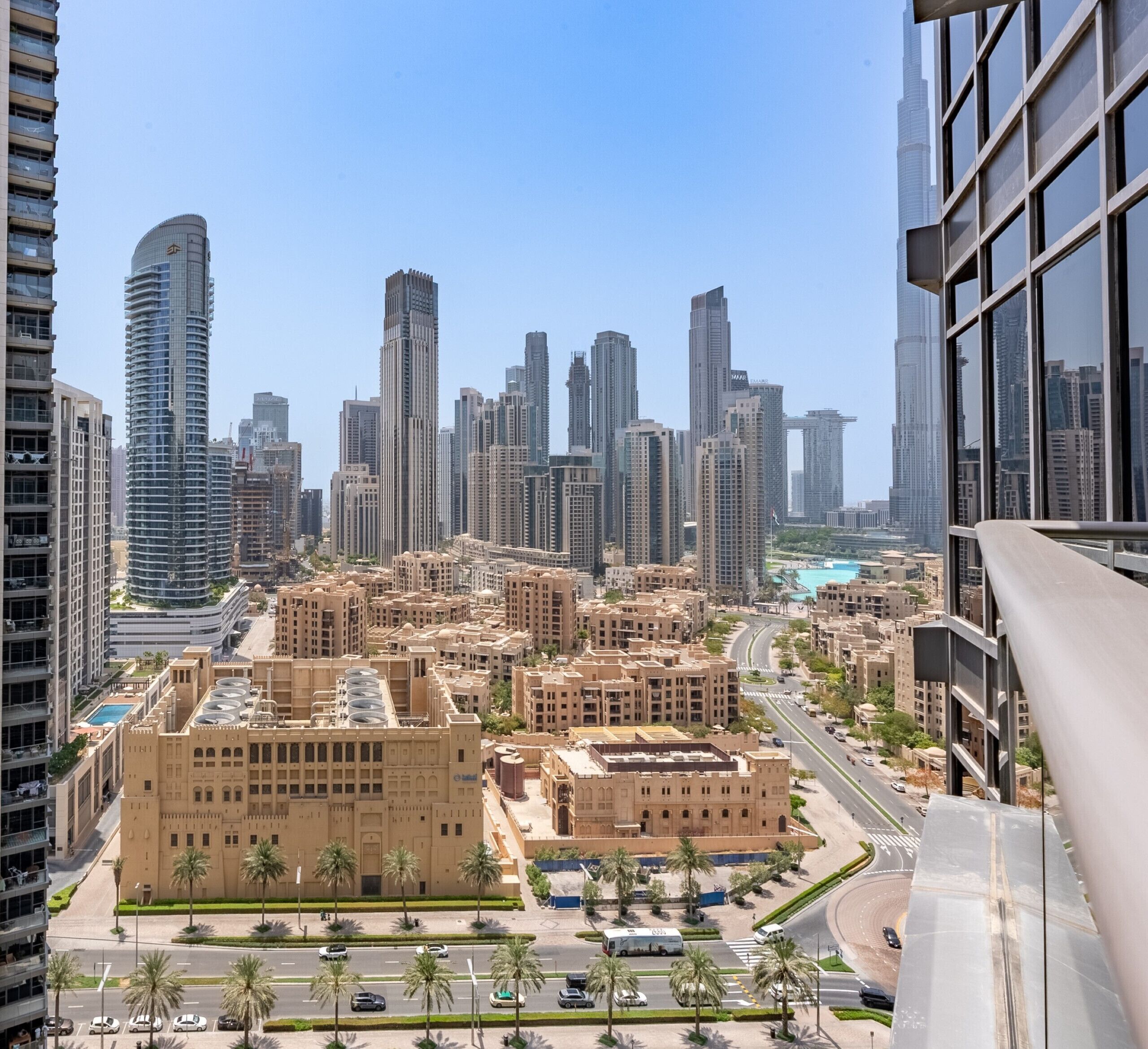 Paesaggio urbano con moderni grattacieli, edifici residenziali e commerciali, e cielo sereno.