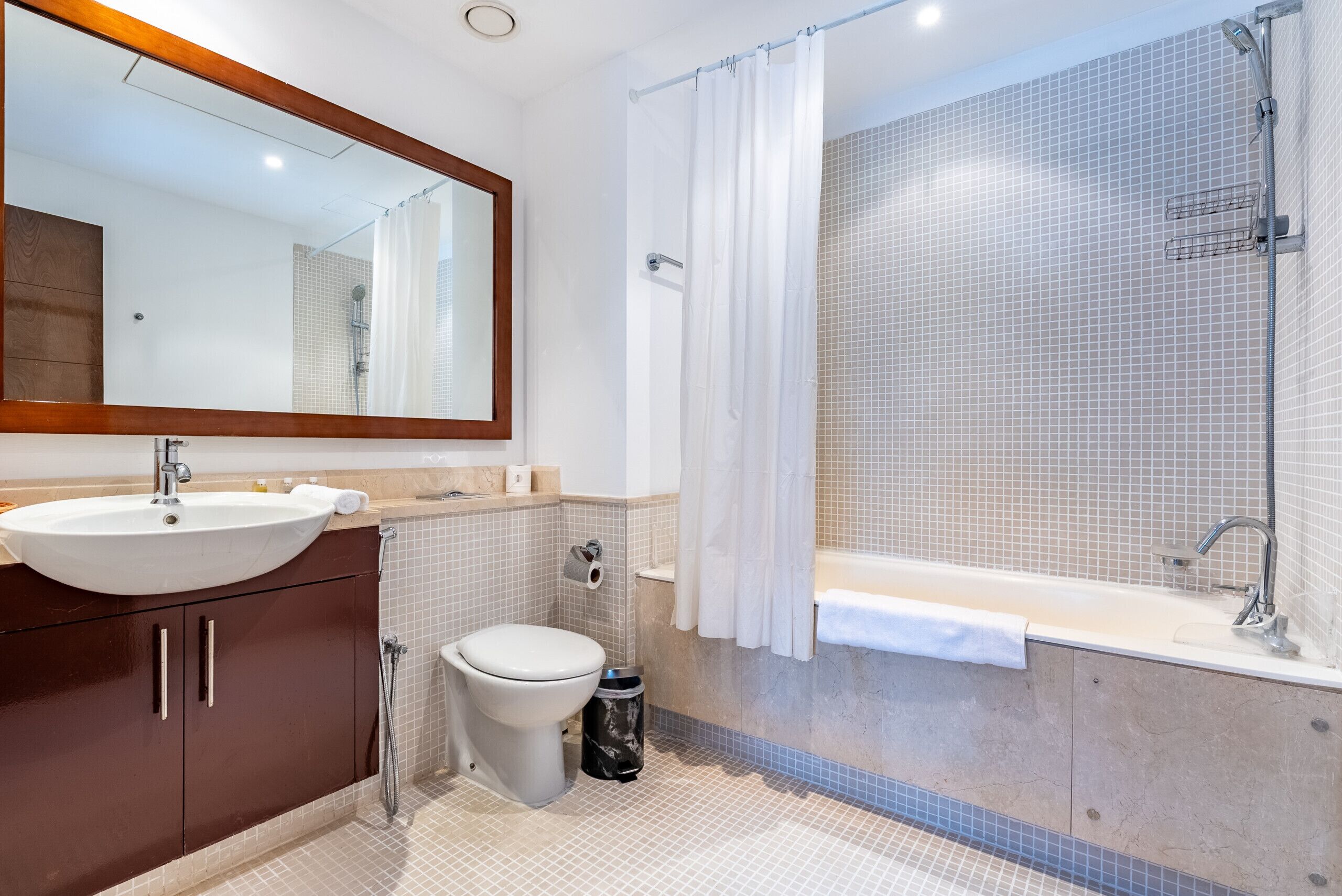 Une salle de bain moderne équipée d’un lavabo, de toilettes, d’une douche et d’une baignoire.