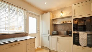 A modern kitchen with a window, built-in cabinets, a countertop, and a built-in oven. - Host & Stay | Belvedere Terrace (Scarborough)