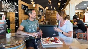 Un espace bar avec des murs en bois, des décorations en forme d’étoiles et un tableau affichant le menu.