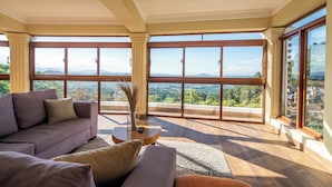 Un salon spacieux doté d’une grande fenêtre offrant une vue sur les montagnes.