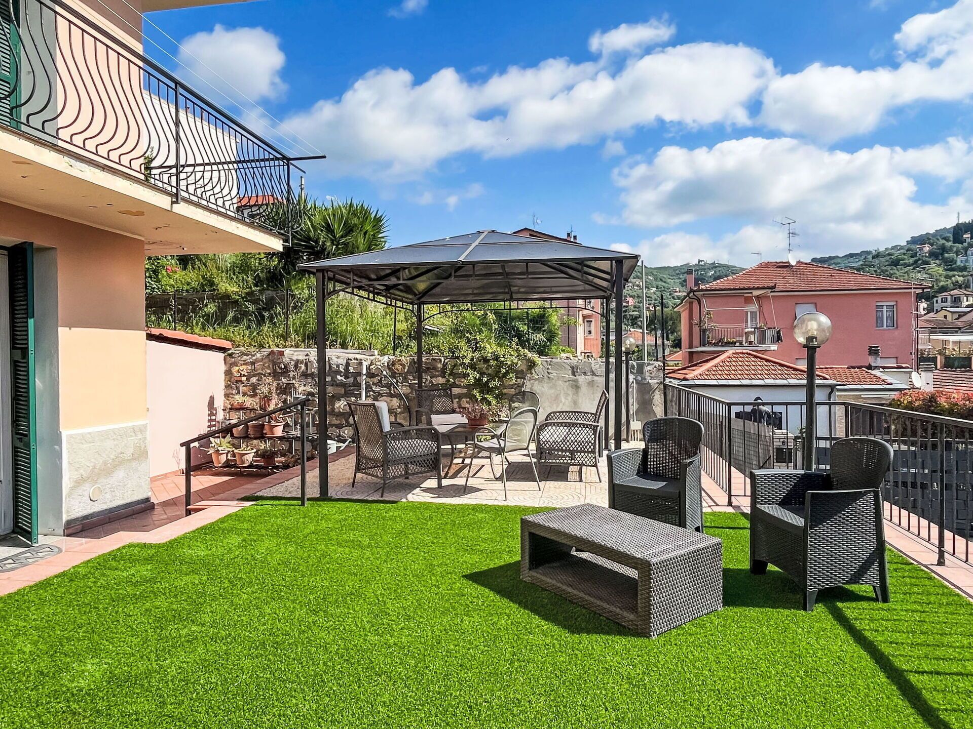 A patio with outdoor furniture, a pergola, and a well-maintained lawn.