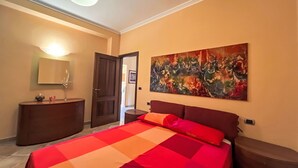 Ein Schlafzimmer mit einem Bett, einem Schminktisch, einem Spiegel und einem Bild an der Wand.