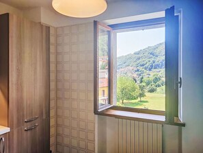 Un baño con ventana, muebles de madera y radiador.
