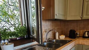 Une cuisine avec une fenêtre, un évier et des placards.