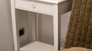 A bed with a quilted cover and a white bedside table with a drawer. - Mi Tú Apartments (Catania)