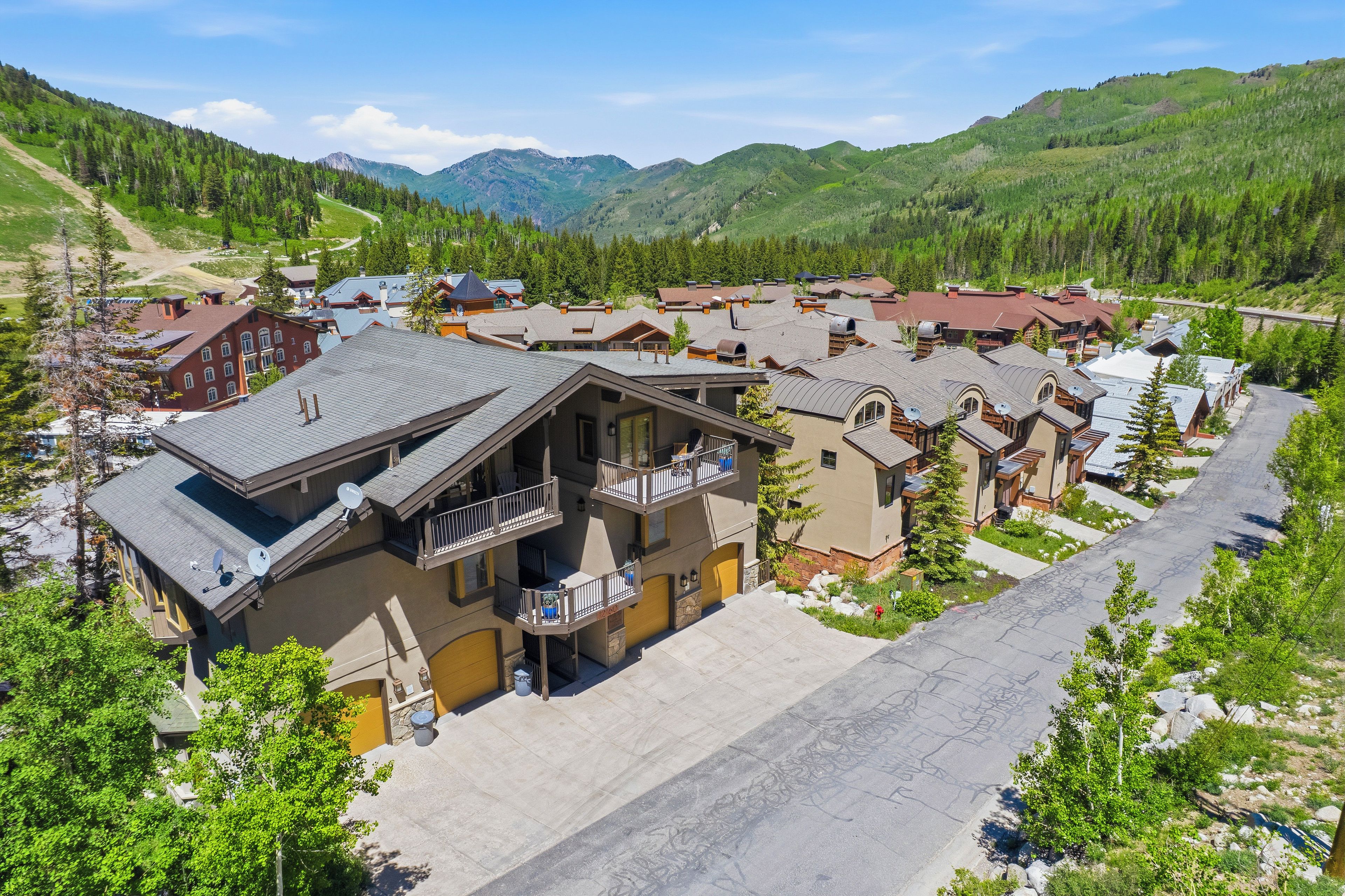 Un quartier résidentiel avec des maisons, une route asphaltée et une chaîne de montagnes en arrière-plan.
