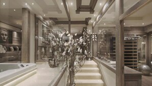 Uma escadaria imponente com corrimão de vidro, piso de mármore e design de interiores moderno.
