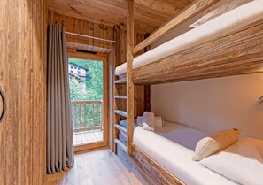 A wooden cabin with a bunk bed, a balcony, and a view of a house. - 5-Bedroom Chalet with Wellness Area (Les Deux Alpes)