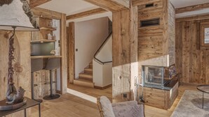 Ein Holzinnenraum mit Treppe, Bar und Sitzgelegenheiten.