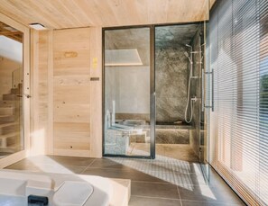 Ein modernes Badezimmer mit Duschkabine aus Glas, Holzwänden und Fliesenboden.