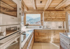 Eine Küche mit Holzausstattung, einem großen Fenster und Blick auf eine Stadt.