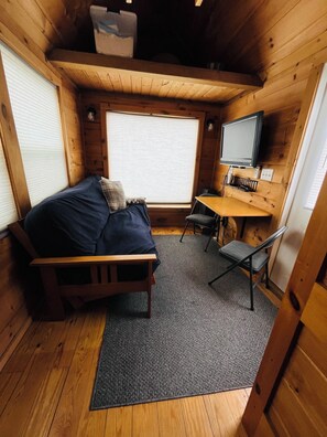 Ein kleines Zimmer mit einem Bett, einem Schreibtisch und einem Stuhl.
