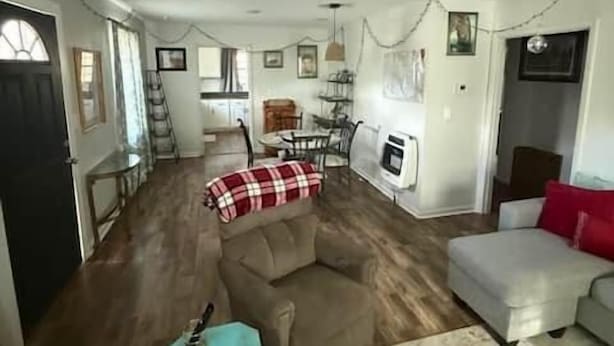 A living room with a sofa, ottoman, and a small table. There is a dining area with a table and chairs. - Reel'em Inn fishing cabin in the Heart of Pickwick (Hardin County)
