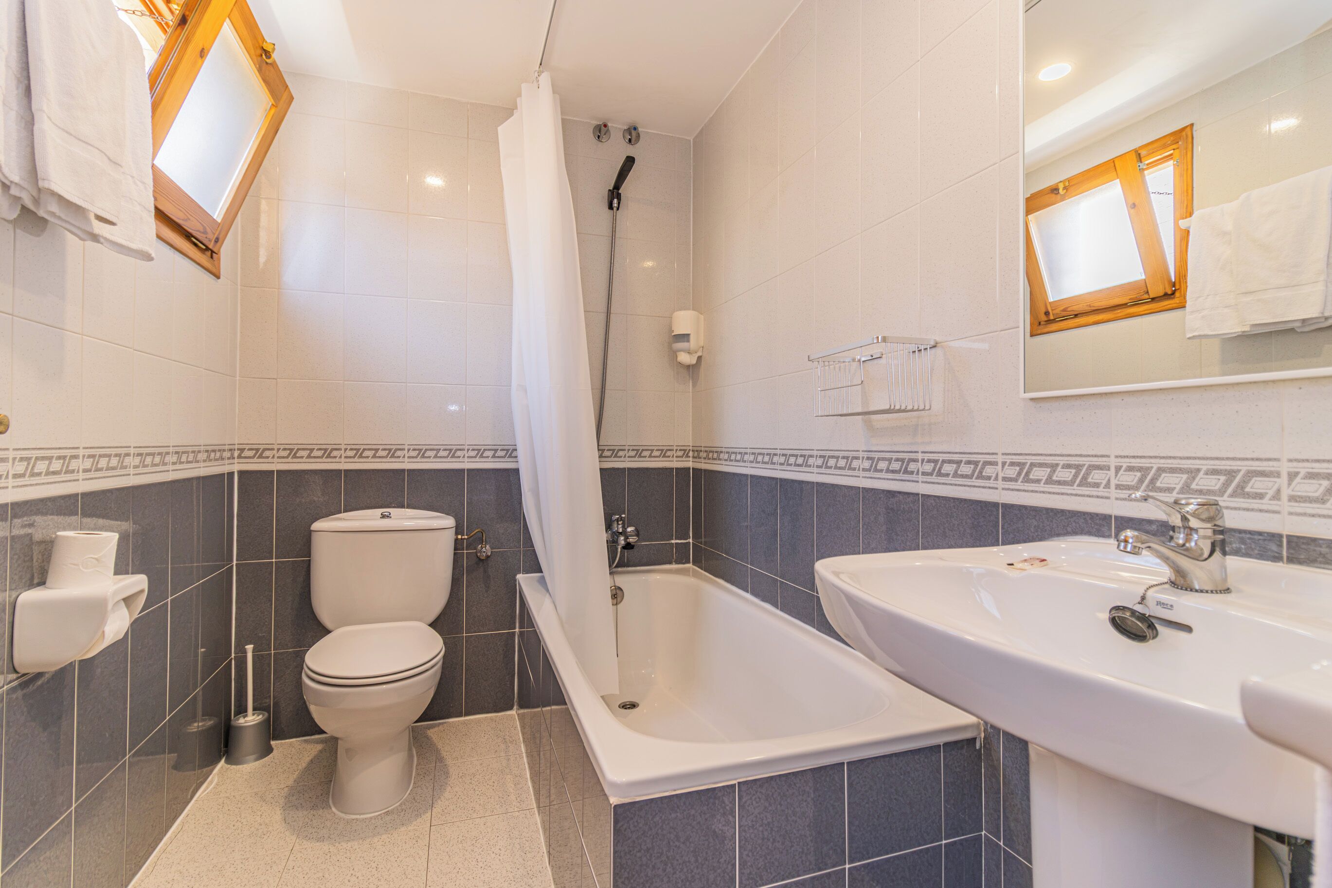 Une salle de bain moderne équipée d’une baignoire, de toilettes et d’un lavabo.