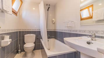 Une salle de bain moderne équipée d’une baignoire, de toilettes et d’un lavabo.