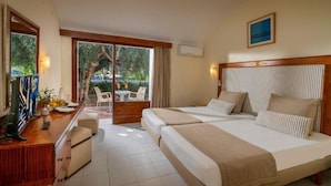 Habitación de hotel con cama, escritorio, silla y vistas al exterior.