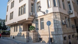 Un edifici de diverses plantes amb un estil arquitectònic clàssic, amb arcs a les finestres i un balcó.