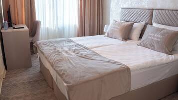 Habitación de hotel con una cama grande, un escritorio y una silla.