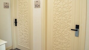 Un passadís amb dues portes, cadascuna amb una placa porta números i una clau.